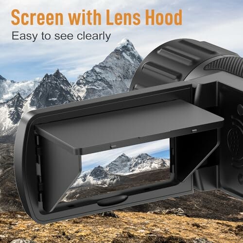 Camera screen with lens hood displaying mountain landscape.